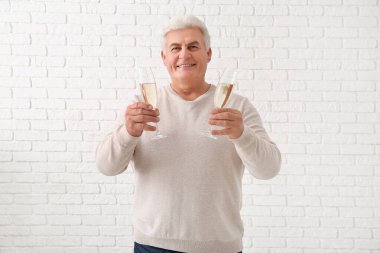 Beyaz tuğlalarla Noel 'i kutlayan şampanya kadehli son sınıf öğrencisi.