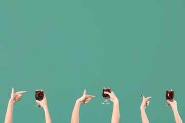 Yeşil arka planda sıcak şarap kadehleriyle kadın elleri.