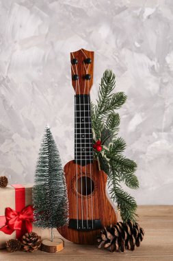 Ukulele ile kompozisyon, Noel hediyesi ve ahşap masa üzerindeki süslemeler grunge arka plan
