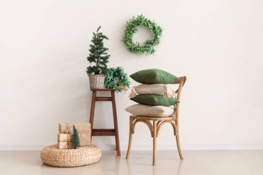 Evin içi dekoratif yastıklarla, minicik Noel ağacı ve ökseotu çelenkleriyle dolu.