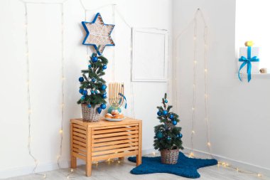 Parlayan ışıkları, köknar ağaçları ve geleneksel Hanuka süslemeleri olan festival salonu.