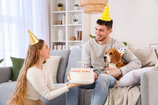 自宅で誕生日を祝うケーキとビーグル犬と幸せな若いカップル — ストック写真