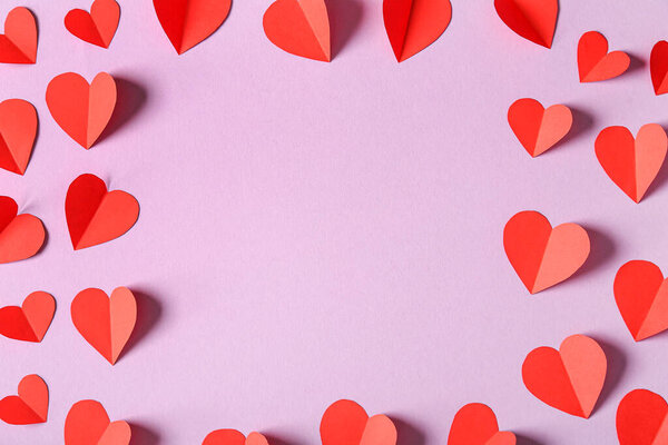 Рама из красных бумажных сердец на сиреневом фоне. Празднование Дня Святого Валентина