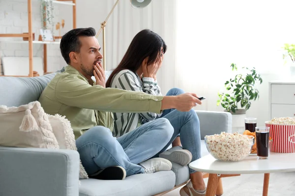 Evde televizyon izleyen korkmuş bir çift.