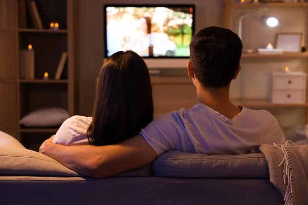 Couple watching TV at home in evening