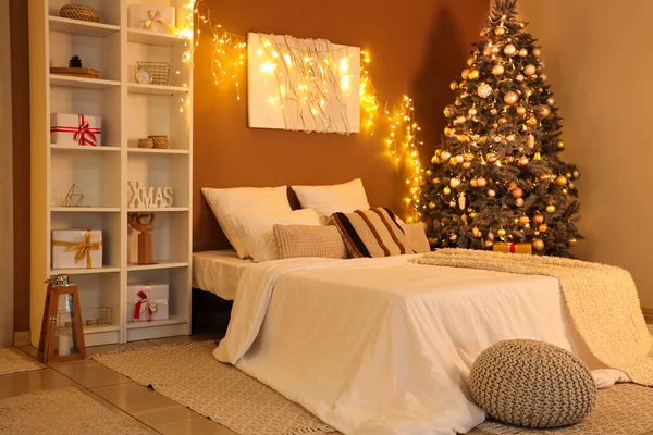 Parlayan ışıklarla dolu bir yatak odası, Noel ağacı ve akşamları raf ünitesi.