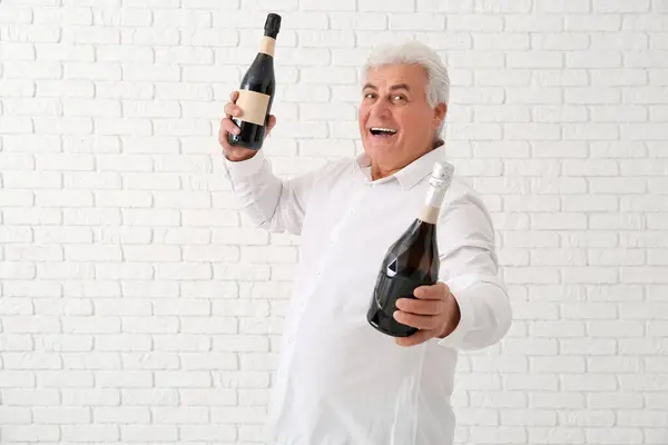 Glücklicher Senior Mit Champagnerflaschen Die Weihnachten Auf Weißem Backsteinhintergrund Feiern — Stockfoto
