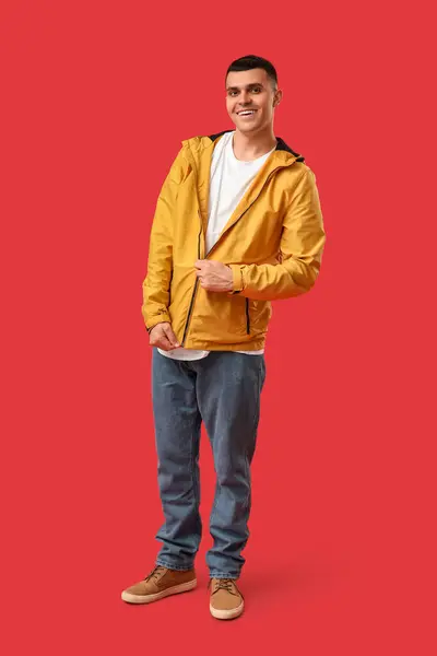 Kırmızı Arka Planda Şık Ceketli Genç Adam — Stok fotoğraf