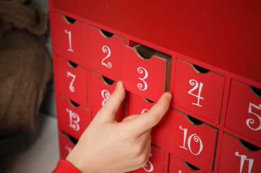 Evde Noel takvimi olan küçük çocuk, yakın plan.