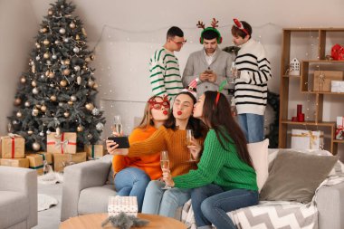 Şampanyalı genç kadınlar yeni yılı ev partisinde kutluyor.