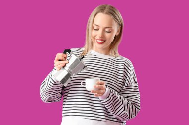 Güzel genç bir kadın gayzer kahve makinesinden fincana mor arka planda espresso dolduruyor.