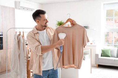 Yakışıklı, buharlı giysiler ve modern bir buharlı ev.