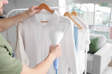 Yakışıklı, buharlı giysiler ve modern bir buharlı ev.