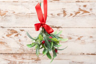 Hafif ahşap arka planda kurdeleli ökseotu dalı