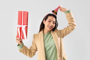 Noel Baba şapkalı genç Asyalı kadın.