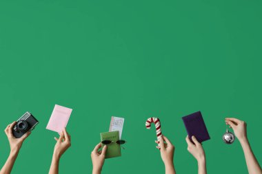 Pasaportları kameralı ve yeşil arka planda Noel dekoru olan kadın eli. Yeni yıl tatili kavramı