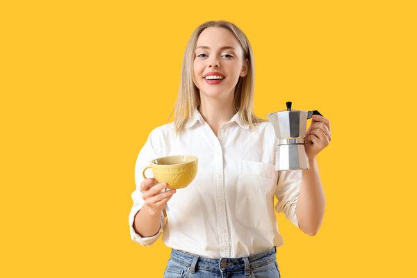 Pretty young woman with geyser coffee maker and cup of espresso on yellow background