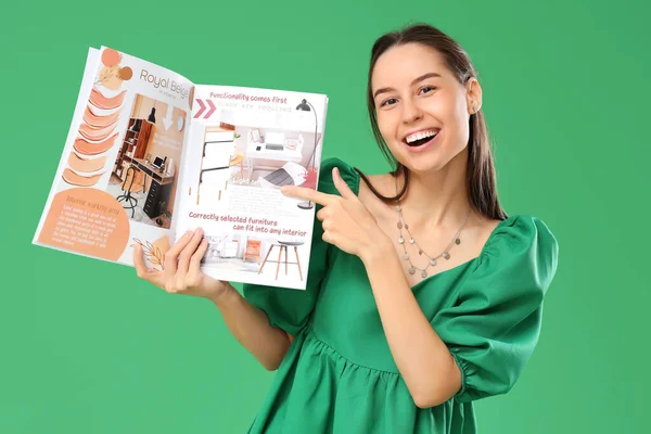 Młoda Kobieta Wskazująca Otwarty Magazyn Zielonym Tle — Zdjęcie stockowe