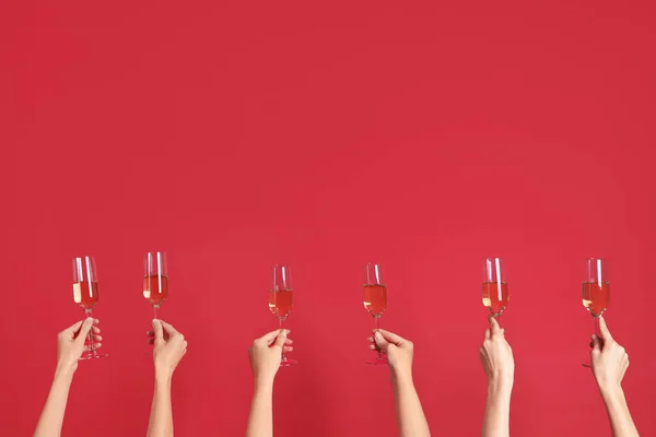 Vrouwelijke Handen Met Glazen Champagne Rode Achtergrond — Stockfoto