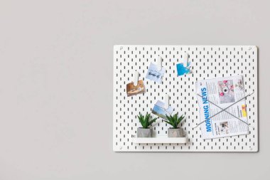 Işık duvarında resimler, gazete ve bitkiler olan tahta.