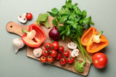 Taze sebzeli ahşap tahta ve gri arka planda yeşillik.
