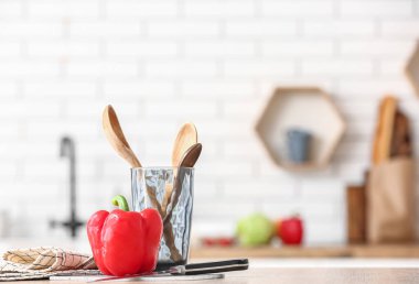 Mutfaktaki masada mutfak aletleri ve taze dolma biber var.