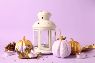 Altın yapraklı boyanmış balkabakları ve leylak arkaplanda yanan mumlar.