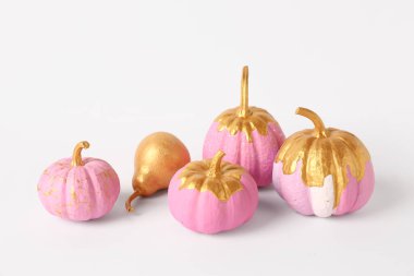 Beyaz arka planda altın armutla boyanmış balkabakları