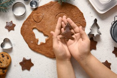 Beyaz arka planda çiğ Noel kurabiyesi olan bir kadın.