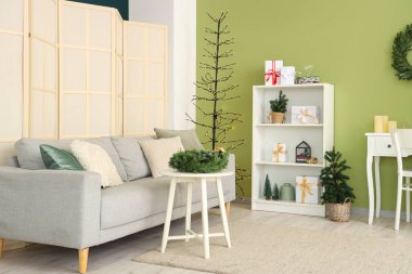 Gri kanepesi, Noel ağacı ve süslemeleri olan şenlikli bir oturma odası.