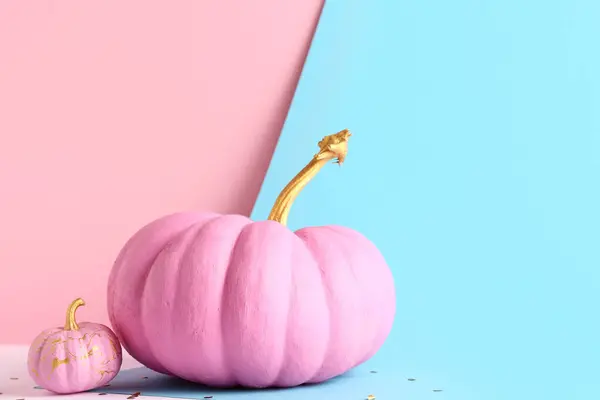 Pink painted pumpkins on colorful background