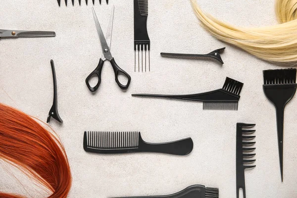Different hair with set of hairdresser\'s tools on grey background