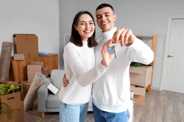 Happy young couple with key in their new flat