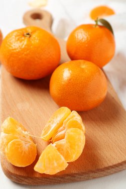 Beyaz arka planda tatlı mandalinalı ahşap tahta, yakın plan.