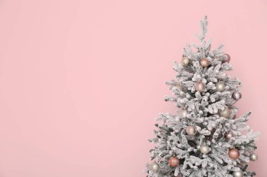 Pembe arka planda güzel süslenmiş Noel ağacı