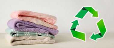 Açık arkaplanda örülmüş süveterler ve geri dönüşüm sembolü. Ekoloji kavramı