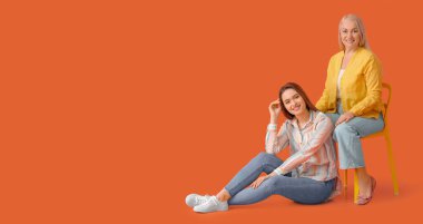 Turuncu arka planda genç kadın ve annesinin portresi