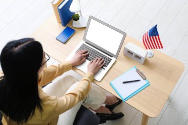 Masada ABD bayrağı taşıyan dizüstü bilgisayar kullanan kadın
