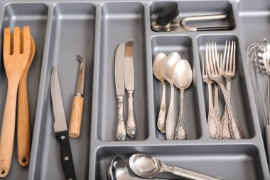 Farklı gümüş çatal bıçaklarla mutfak çekmecesini aç