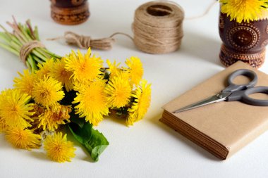 Güzel karahindiba çiçekleri, halat, makas ve açık arkaplan üzerine kitap.