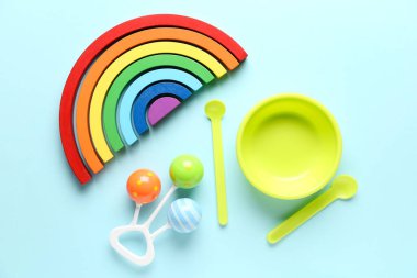 Eğitici oyuncak blokları, bebek çıngırağı ve beslenme seti mavi arka planda