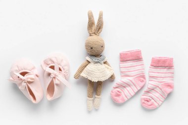 Beyaz arka planda bebek çorapları olan örgü bir oyuncak.
