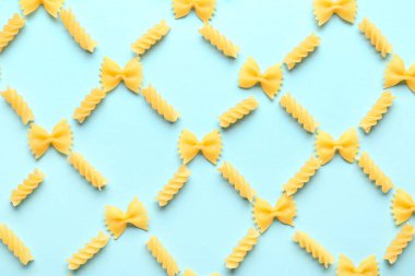 Pişmemiş farfalle ve mavi arka planda fusilli makarna ile kompozisyon
