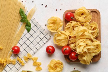 Farklı pişmemiş makarna, domates ve baharatlı kompozisyon.