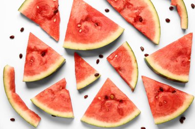 Taze karpuz parçaları ve beyaz arka planda tohumlar.