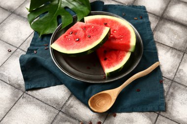 Taze karpuz parçaları ve gri fayanslı tohumlarla kaplı bir tabak.