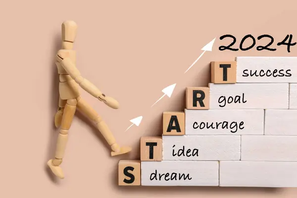 Banner with wooden mannequin, blocks, text START 2024, SUCCESS, GOAL, COURAGE, IDEA, DREAM on beige background