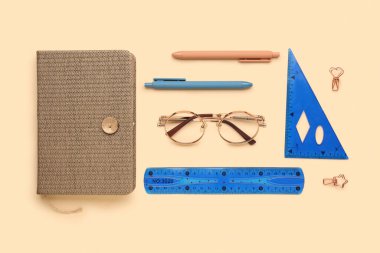 Bej arka planda şık gözlüklü ve kırtasiyeli kompozisyon