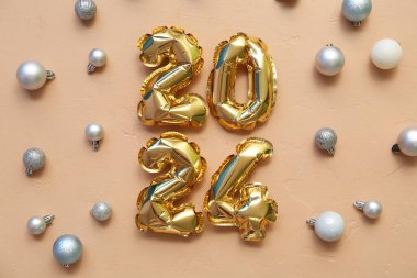 Bej arka planda Noel topları olan balonlardan yapılmış 2024 numaralı figür.