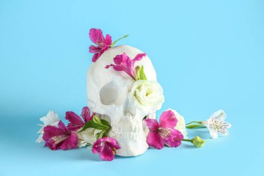 Mavi arka planda güzel çiçekli insan kafatası